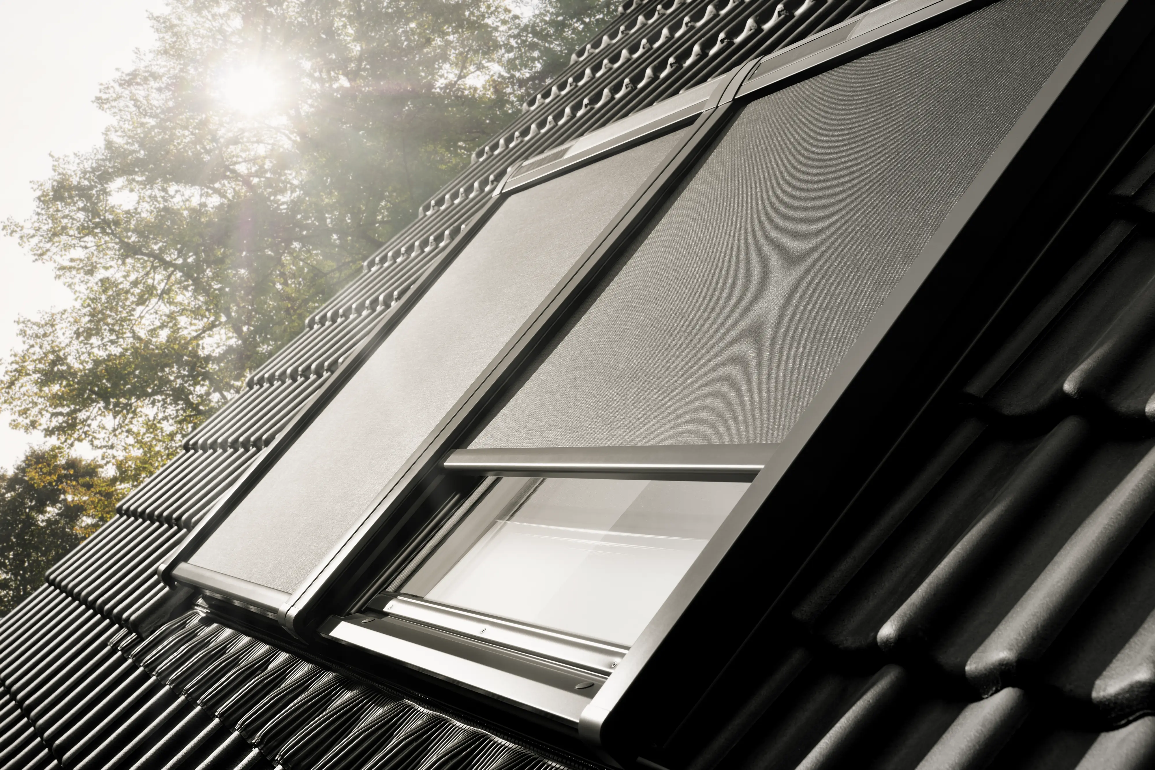 Store extérieur anti-chaleur VELUX installé sur une fenêtre de toit en plein soleil