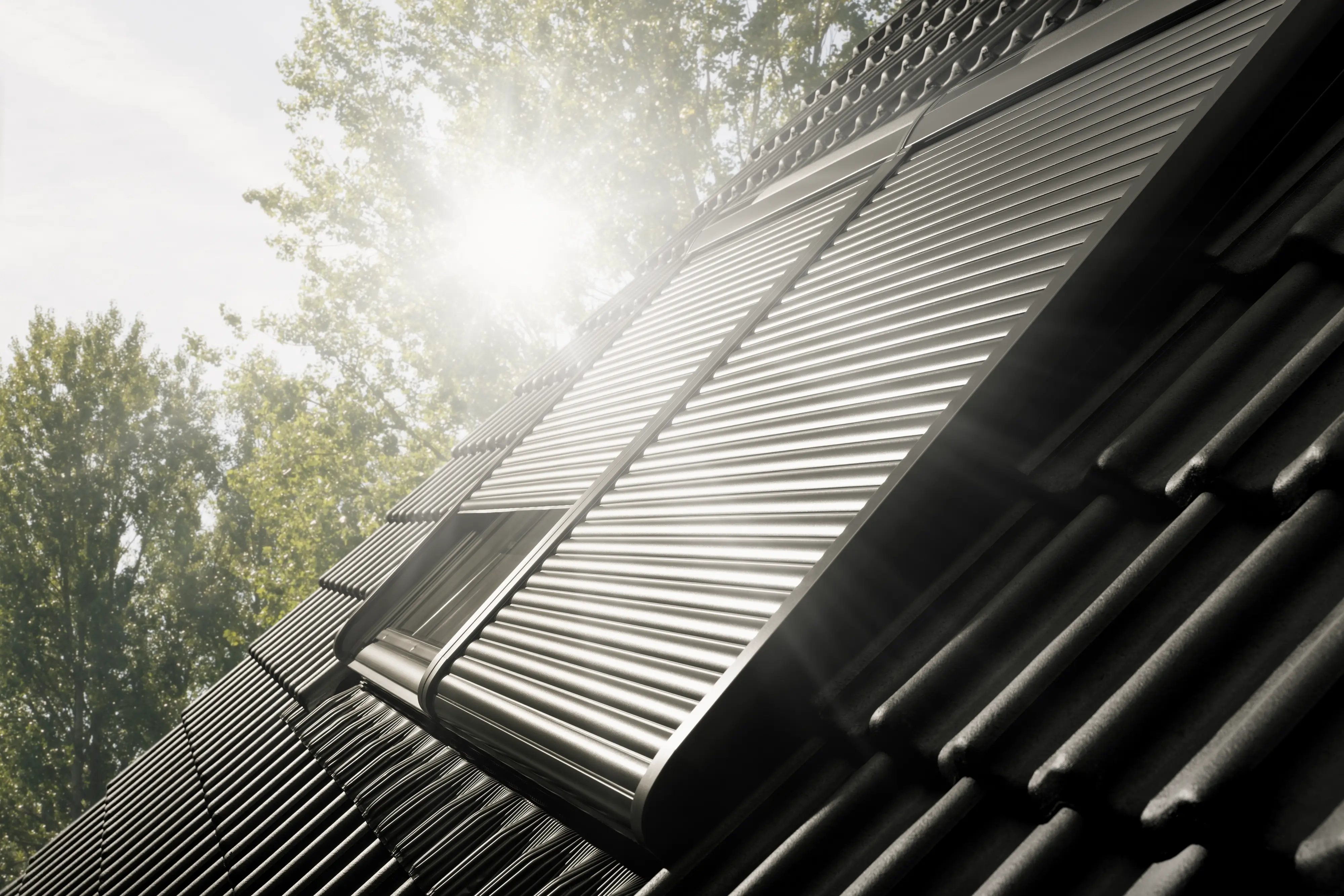 Volet roulant extérieur VELUX fermé sur une fenêtre de toit exposée au soleil